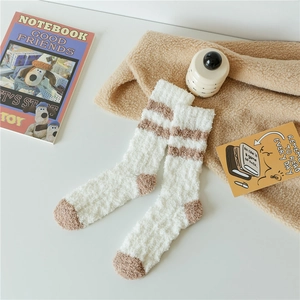 Detail of coral fleece socks with brown stripes and warm plush texture for winter