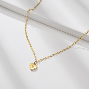 Vue macro détaillée d'un pendentif cœur doré avec zircon sur une chaîne trombone stylée