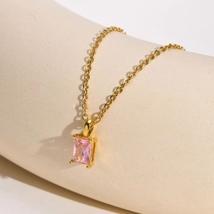 Detail of gold-plated cross chain with a rectangle pink zircon pendant in a claw setting