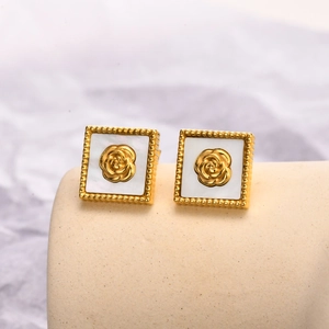 Gros plan de boucles d'oreilles vintage carrées dorées avec nacre et rose en relief