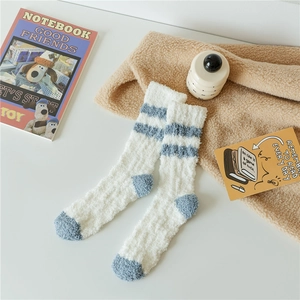 Detail of coral fleece winter socks in white with blue stripes and thickened plush texture