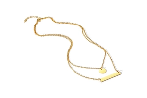 Detailed view of gold double-layer necklace with circular and bar pendants on white background