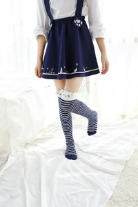 Détail de chaussettes hautes rayées bleu et blanc en polaire corail avec oreilles de chat