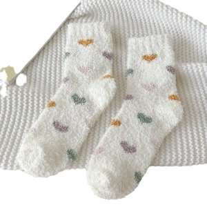 Thick plush coral fleece crew socks featuring colorful heart patterns on a white background