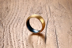 Macro shot of 8mm gold brushed tungsten ring with polished blue inner band and engraving