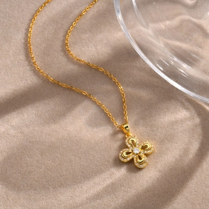 Macro view of gold flower pendant necklace featuring pave set cubic zirconia crystals