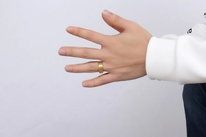 Close-up of 8mm golden tungsten steel ring with matte finish on a male model hand