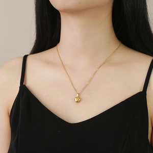 Collana con ciondolo a cuore d'oro lucido su collo di modella con catena sottile
