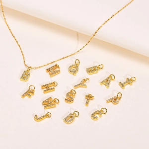 Collier alphabet DIY en acier doré avec pendentifs lettres en zircon sur tissu blanc