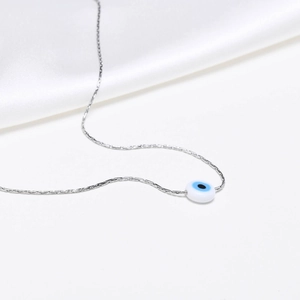 Detail view of a blue evil eye bead pendant on a polished stainless steel chain