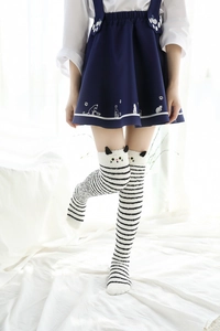 Détail de chaussettes hautes rayées avec design oreilles de chat et broderie