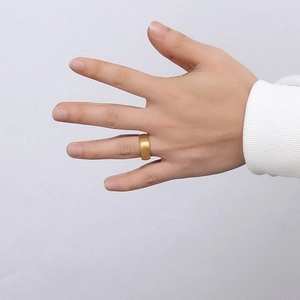 8mm gold tungsten carbide ring with a brushed matte finish shown on a person's hand