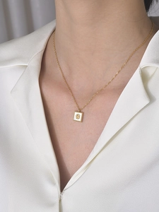 Détail d'un collier rose doré vintage avec nacre blanche sur chemisier en soie