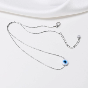 Macro view of silver evil eye necklace with lobster clasp and extension chain