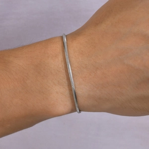 Detailed view of silver flat snake chain bracelet with dense woven metallic texture