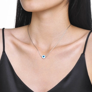 Classic golden evil eye pendant necklace for women shown on a model neck