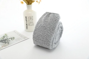Gros plan de chaussettes grises en polaire corail montrant une texture douce et pelucheuse