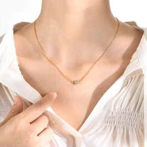 Gros plan d'un collier en acier inoxydable doré avec pendentif en zircon blanc rond