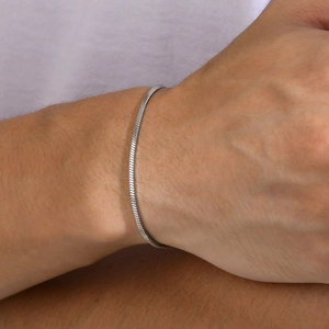 Close-up of minimalist silver snake chain bracelet showing smooth texture on wrist