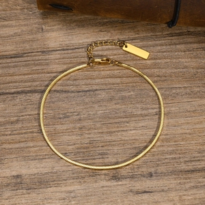 Detail of gold square snake chain with lobster clasp and extension link on wood background