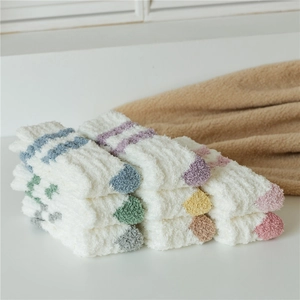 Detail of plush coral fleece thermal socks featuring colorful stripe patterns for winter