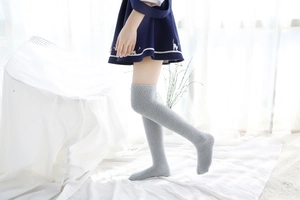 Détail de chaussettes de nuit hautes gris clair en polaire corail texture peluche
