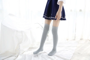 Gros plan sur des chaussettes montantes en polaire corail gris clair avec jupe plissée