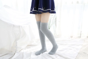 Détail de chaussettes hautes en polaire corail grise avec texture douce et poignets élastiques