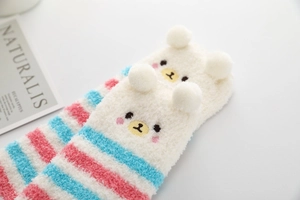 Détail de chaussettes de sommeil en polaire corail avec oreilles d'ours 3D