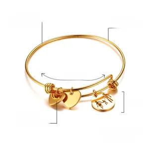 Détails d'un bracelet en acier inoxydable doré avec pendentifs en cœur et motif famille