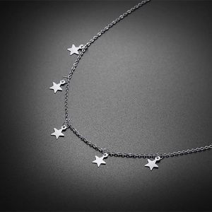 Vue macro d'un collier en acier inoxydable poli avec cinq pendentifs étoiles minimalistes
