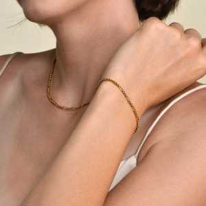 Détail d'un ensemble collier et bracelet en chaîne à billes dorées avec maillons