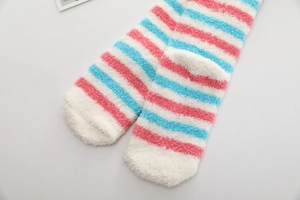 Détail de chaussettes longues en polaire corail à rayures roses et bleues douces