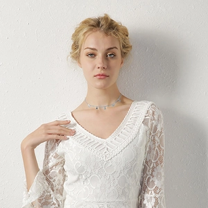 Détail du collier choker à étoiles argentées porté avec un haut en dentelle blanche