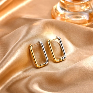 Close-up of geometric rectangle hoop earrings in gold and silver two-tone stainless steel