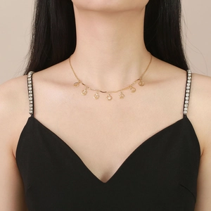 Collana in acciaio inossidabile dorato con simboli della pace indossata su top nero a V