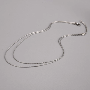 Close-up of double-layer stainless steel necklace with lobster clasp and extension chain