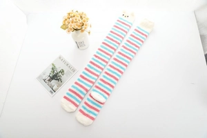 Détail de la texture des chaussettes hautes rayées en polaire corail avec broderie ours
