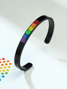 Macro detail of black stainless steel cuff bangle with rainbow pride enamel rectangle