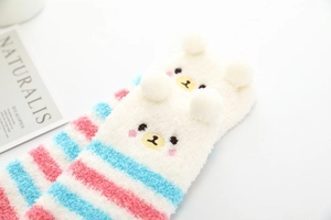 Détail de chaussettes hautes en polaire corail avec rayures et motif ours mignon