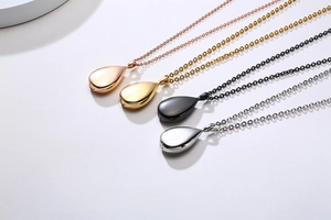 Detailed view of teardrop urn pendants in rose gold, gold, black, and silver finishes