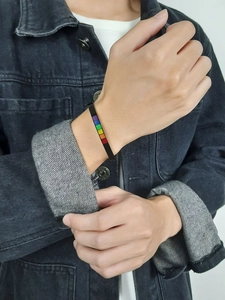 Close-up of black stainless steel C-shaped cuff bracelet with LGBT rainbow enamel inlay