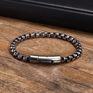 Detail of vintage silver stainless steel box chain bracelet on wood background