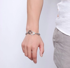 Polished stainless steel handcuff link bracelet for men shown on a model's wrist