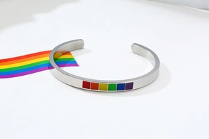 Detailed close-up of C-shaped stainless steel cuff with rainbow enamel inlay design