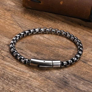 Detail of masculine vintage steel box chain bracelet with industrial cylinder clasp