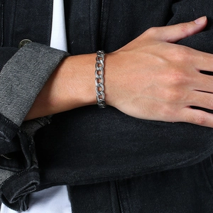 Nahaufnahme eines maskulinen silbernen Edelstahl-Panzerarmbands am Handgelenk