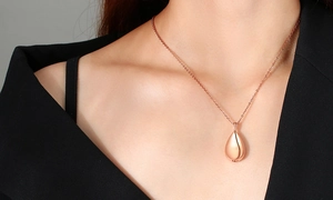 Rose gold teardrop cremation pendant on female model wearing black blazer suit
