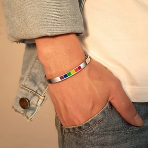 Macro detail of rainbow colored inlay on polished stainless steel open cuff bracelet