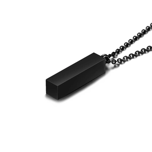 Detailed close-up of a matte black rectangular pendant on a matching steel chain
